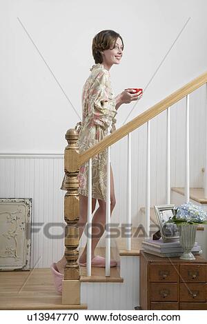 Mid adult woman with tea cup walking up stairs in morning View Large Photo Image Stock Image - Mid adult woman with tea cup walking up stairs in morning. Fotosearch