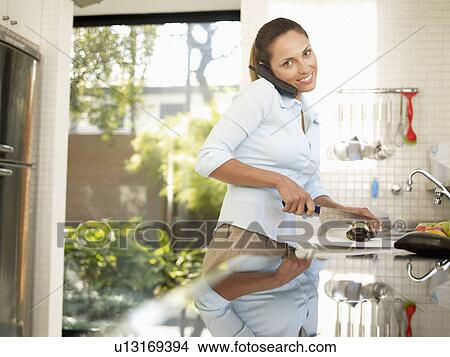 Young woman chopping eggplant and talking on phone View Large Photo Image Picture - Young woman chopping eggplant and talking on phone. Fotosearch
