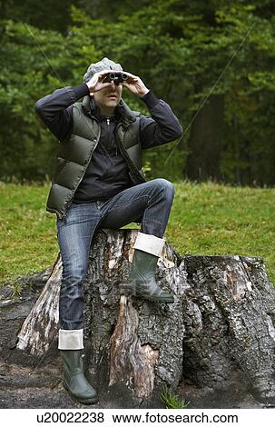 Man Using Binoculars on Tree Stump View Large Photo Image Stock Photo - Man Using Binoculars on Tree Stump. Fotosearch