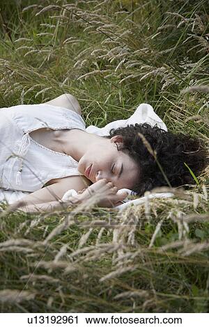 Young woman lying on tall grass View Large Photo Image Stock Image - Young woman lying on tall grass. Fotosearch