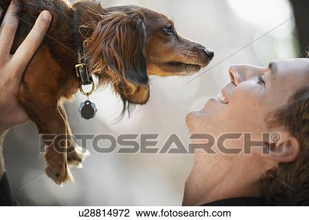 Man holding dog near his face (profile) View Large Photo Image Stock Image - Man holding dog near his face (profile). Fotosearch