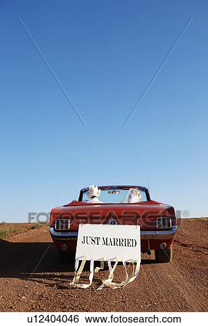 Stock Photograph - Newlyweds driving convertible through desert, Arizona, USA. Fotosearch