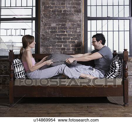 Young Couple Fighting with Pillows View Large Photo Image Picture - Young Couple Fighting with Pillows. Fotosearch