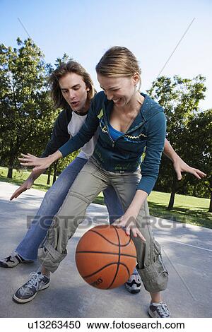 Stock Image - Young couple playing basketball. Fotosearch