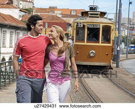 Stock Image - Young Couple Walking by Streetcar Track. Fotosearch