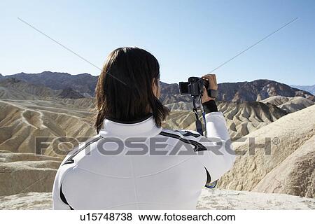 Man using video camera in desert (rear view), Death Valley, California, USA View Large Photo Image Stock Photo - Man using video camera in desert (rear view), Death Valley, California, USA. Fotosearch