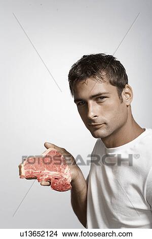 Mid adult man holding steak View Large Photo Image Picture - Mid adult man holding steak. Fotosearch