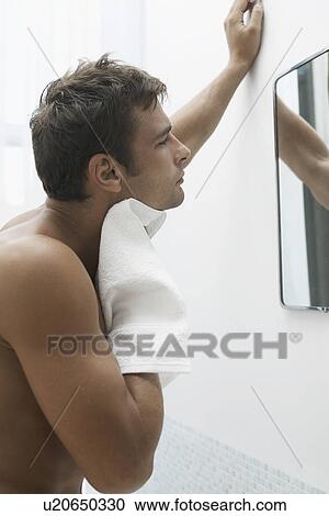 Mid adult man looking in bathroom mirror View Large Photo Image Stock Image - Mid adult man looking in bathroom mirror. Fotosearch
