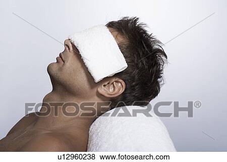 Mid adult man lying with towel over eyes View Large Photo Image Stock Photo - Mid adult man lying with towel over eyes. Fotosearch