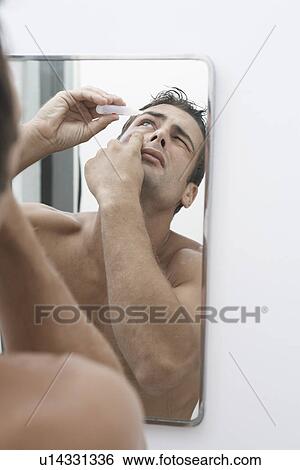 Mid adult man putting in eye drops View Large Photo Image Stock Photograph - Mid adult man putting in eye drops. Fotosearch