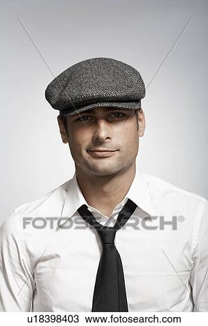 Stock Image - Mid adult man wearing cap. Fotosearch