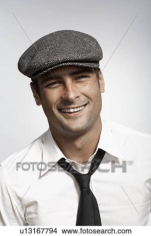 Picture - Mid adult man with cap smiling. Fotosearch