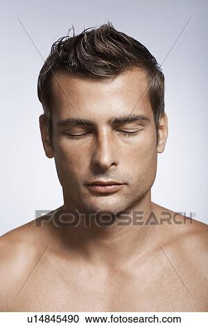 Stock Image - Mid adult man with eyes closed. Fotosearch