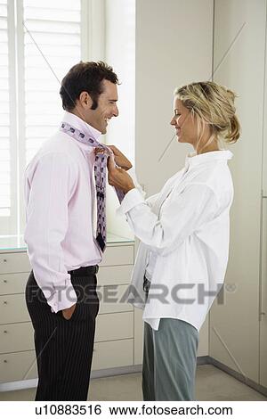 Woman tying necktie for husband View Large Photo Image Stock Photograph - Woman tying necktie for husband. Fotosearch