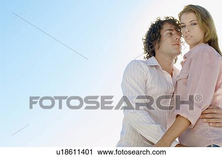 Young couple against clear sky (portrait, low angle view) View Large Photo Image Stock Image - Young couple against clear sky (portrait, low angle view). Fotosearch