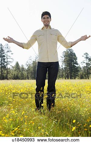 Young man standing in a field of wildflowers View Large Photo Image Stock Image - Young man standing in a field of wildflowers. Fotosearch
