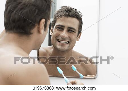Mid adult man cleaning teeth View Large Photo Image Stock Photo - Mid adult man cleaning teeth. Fotosearch