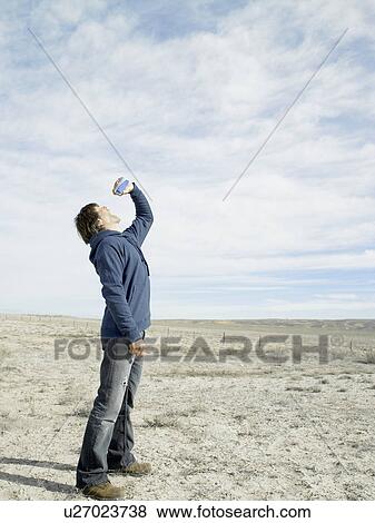 Mid adult man drinking beer in desert View Large Photo Image Stock Photo - Mid adult man drinking beer in desert. Fotosearch