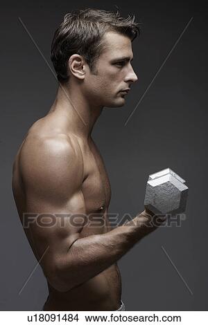 Mid adult man lifting dumbbell View Large Photo Image Picture - Mid adult man lifting dumbbell. Fotosearch
