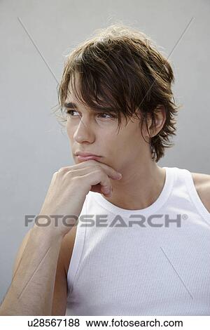 Stock Photo - Young man with chin on hand (portrait). Fotosearch