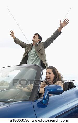 Stock Photograph - Carefree Couple Driving Convertible. Fotosearch