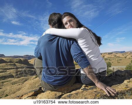 Picture - Couple Sitting on Rock And Looking at View. Fotosearch