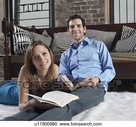 Stock Image - Mid-Adult Couple Reading on Floor. Fotosearch