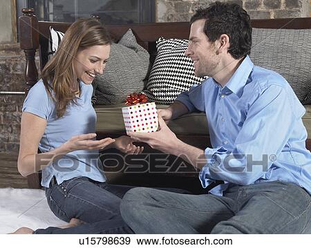Stock Photo - Mid-Adult Man Giving Girlfriend a Gift. Fotosearch