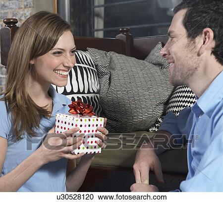 Stock Image - Mid-Adult Woman Receiving Gift from Boyfriend. Fotosearch