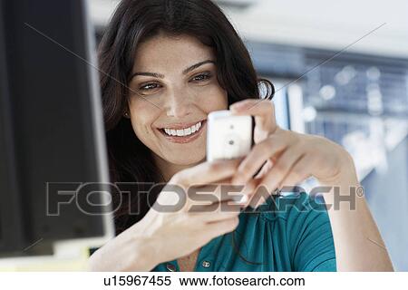 Stock Photography - Female office worker text messaging. Fotosearch