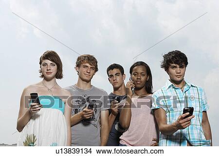 Picture - Five teenagers with mobile phones (low angle view). Fotosearch