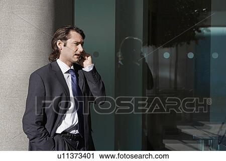Stock Image - Mid Adult Man Talking on Mobile Phone. Fotosearch