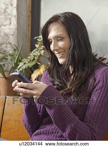Picture - Mid-Adult Woman Text Messaging. Fotosearch