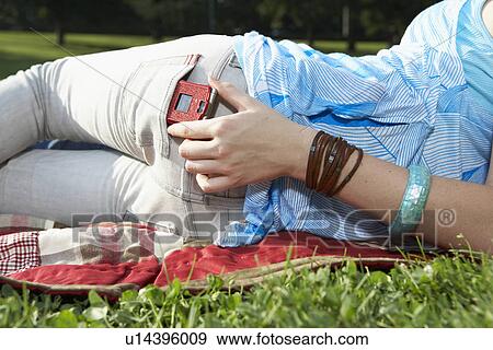 Teenage girl taking mobile phone from back pocket (midsection) View Large Photo Image Stock Photo - Teenage girl taking mobile phone from back pocket (midsection). Fotosearch