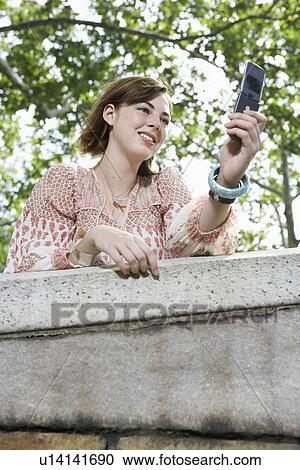 Teenage girl using mobile phone (low angle view) View Large Photo Image Stock Image - Teenage girl using mobile phone (low angle view). Fotosearch