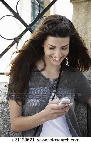 Stock Image - Young woman text messaging. Fotosearch