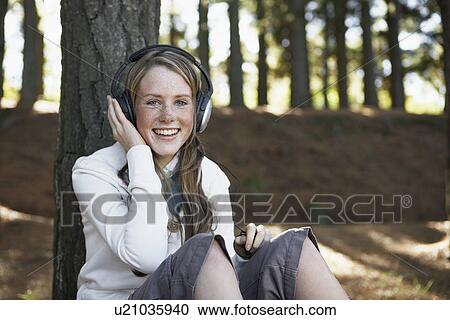 Teenage girl listening to headphones in woods View Large Photo Image Stock Image - Teenage girl listening to headphones in woods. Fotosearch