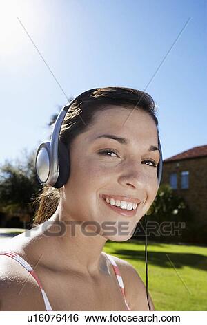 Teenage girl listening to headphones (portrait) View Large Photo Image Stock Photograph - Teenage girl listening to headphones (portrait). Fotosearch