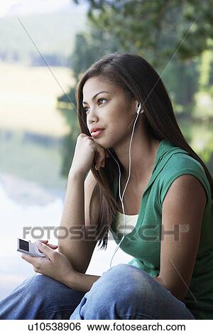 Teenage girl listening to MP3 player View Large Photo Image Stock Photograph - Teenage girl listening to MP3 player. Fotosearch