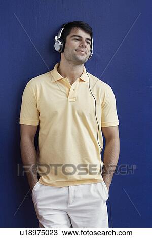 Young man listening to headphones View Large Photo Image Stock Image - Young man listening to headphones. Fotosearch