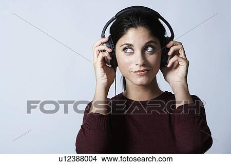 Young woman listening to headphones View Large Photo Image Picture - Young woman listening to headphones. Fotosearch