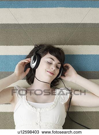 Young Woman Listening to Headphones View Large Photo Image Stock Image - Young Woman Listening to Headphones. Fotosearch