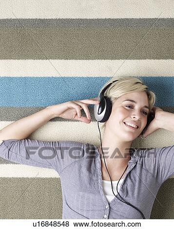 Stock Photo - Young Woman Listening to Headphones. Fotosearch