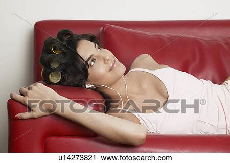 Young woman lying on sofa and listening to MP3 player View Large Photo Image Stock Image - Young woman lying on sofa and listening to MP3 player. Fotosearch