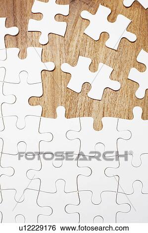 Stock Photograph - Jigsaw puzzle on wooden background. Fotosearch