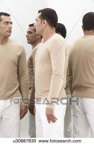 Stock Photo - Man standing by mirrors. Fotosearch