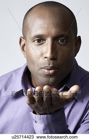 Mid adult man blowing an air kiss View Large Photo Image Stock Image - Mid adult man blowing an air kiss. Fotosearch