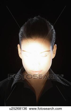 Stock Photograph - Woman's face in spotlight. Fotosearch