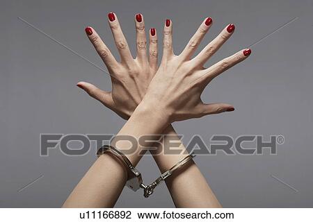 Stock Image - Woman's hands in handcuffs (close-up). Fotosearch