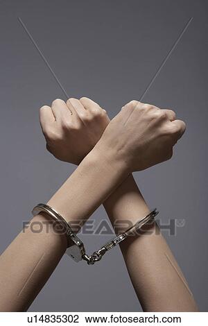 Stock Image - Woman's hands in handcuffs (close-up). Fotosearch